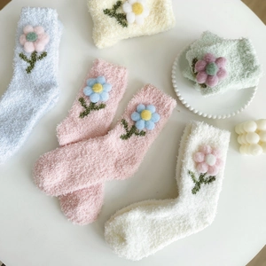 Detail von flauschigen Korallenvlies-Socken mit 3D-Blumenakzenten in weichen Macaron-Tönen