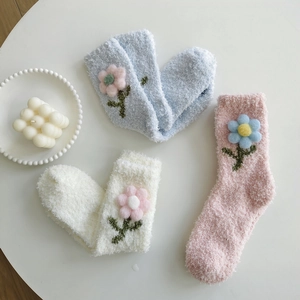 Details von dicken Korallenfleece-Socken in Pastellfarben mit 3D-Häkelblumen
