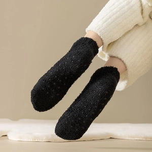 Close-up of black coral fleece warm socks with anti-slip silicone dots on the sole