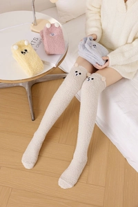 Detailed texture of thick coral fleece over-knee socks with cute cartoon bear ears