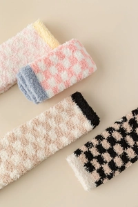 Close-up of thick coral fleece winter socks featuring a soft checkerboard pattern design