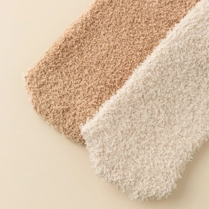 Close-up of caramel and beige coral fleece socks showing thick fluffy material texture