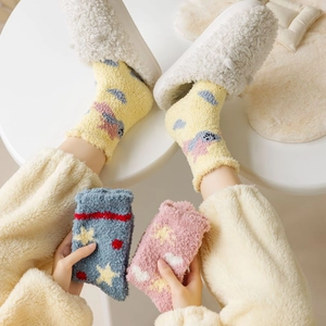 Macro view of thick coral fleece socks with cute cartoon star patterns for winter home