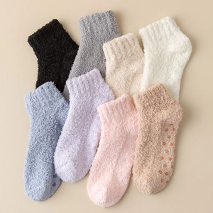 Detail view of colorful fluffy coral fleece socks with anti-slip silicone dots on soles