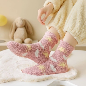 Detail of pink coral fleece socks featuring cute star patterns for cozy winter home wear
