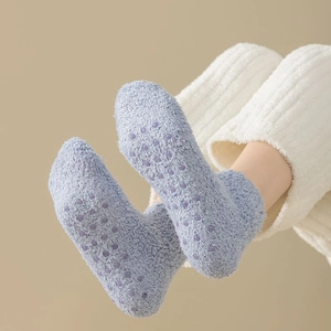 Thick coral fleece socks in light blue with purple non-slip silicone grips on the sole