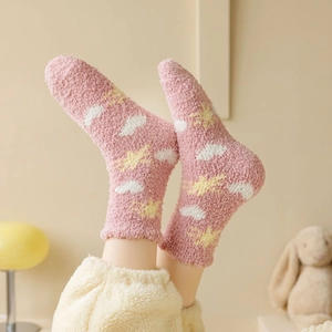 Detail of thick coral fleece socks with cute star and cloud patterns for winter home wear
