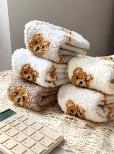 Close-up of thick coral fleece winter socks with cute cartoon bear jacquard pattern
