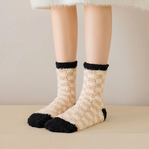 Detail view of thick coral fleece mid-calf socks with beige and black checkerboard pattern