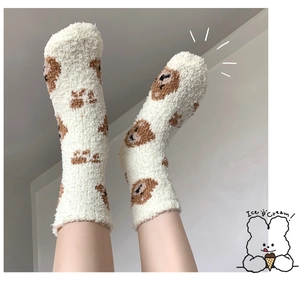 Detailed texture of thick coral fleece socks with cute brown cartoon bear patterns