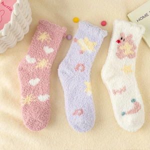 Thick coral fleece socks with cute star and rabbit patterns on a cozy beige rug