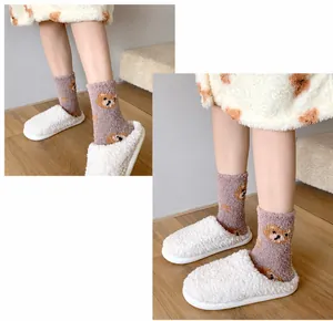 Close-up of soft purple coral fleece socks with cute bear embroidery for winter