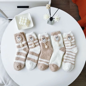 Detail of five pairs of thick coral fleece thermal socks with 3D plush bear charms