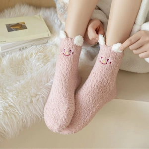 Detail of pink coral fleece socks with cute 3D ears and embroidered smiley face detail