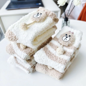 Detailed view of thick coral fleece winter socks with striped pattern and bear ornaments