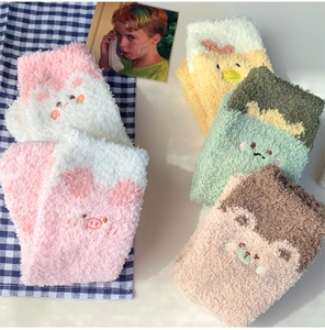 Detailaufnahme flauschiger Korallenvlies-Socken mit süßer Tierstickerei und bunten Farben