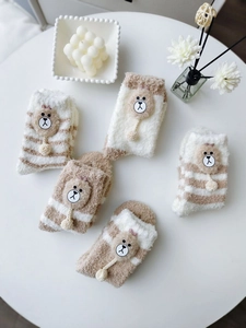 Detailed texture of thick coral fleece socks with cute cartoon bear patches in a 5-pair set