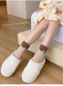 Detail von Korallenvlies-Bärensocken und Plüschhausschuhen für gemütliche Wintermode