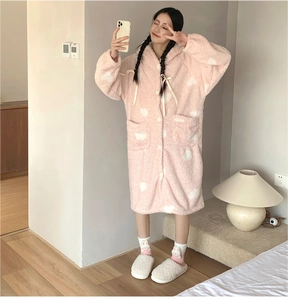 Close-up of pink coral fleece robe with white heart patterns and fuzzy slippers