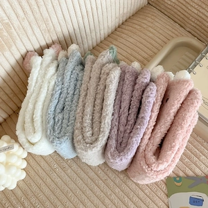 Five pairs of plush coral fleece winter socks in pastel colors with cute pom-pom detail
