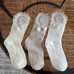 Detailed knit texture of children's crew socks with cat patch and lace trim details