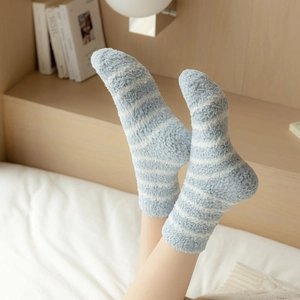 Close-up of soft light blue and white striped coral fleece socks for cozy winter warmth