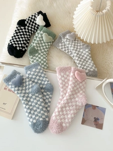 Close-up of five pairs of checkered fleece socks with 3D plush heart decorations