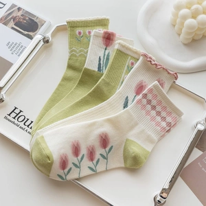 Floral tulip and plaid patterns on green combed cotton mid-tube socks with ruffle trim
