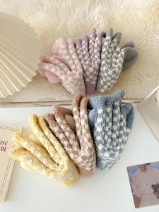 Close-up of thick checkered coral fleece socks in six pastel colors with plush texture