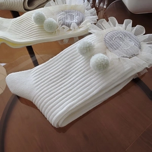 Detailed knit mid-tube sock featuring lace trim, plush pom-poms and cat patch