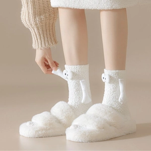 Détail de chaussettes blanches en polaire corail avec yeux 3D et petites mains décoratives