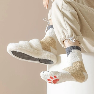 Detail of plush coral fleece cat claw socks and matching slippers for winter comfort