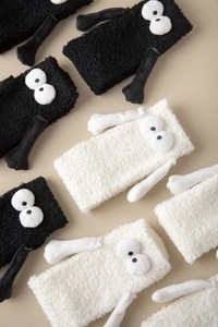 Détail de chaussettes en molleton corail avec yeux 3D amusants et mains aimantées noir-blanc