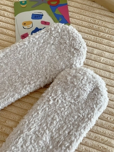 Close-up of thick grey coral fleece socks with fluffy texture and cozy home aesthetic
