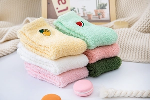 Detail of colorful coral fleece socks with fruit embroidery and warm plush texture