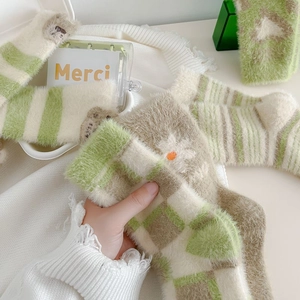 Detailed view of various plush mink velvet socks in green and beige patterns
