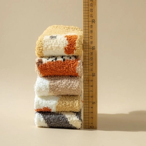 Close-up of five pairs of stacked coral fleece socks showing a 19cm thickness detail