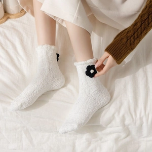 Detail of soft white coral fleece socks with 3D crochet flower on the ankle