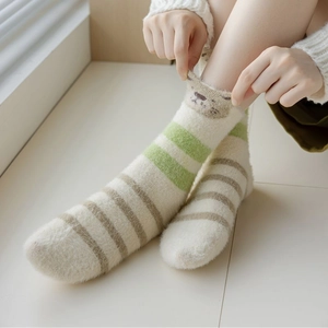 Detailed texture of thick green striped mink velvet socks with cute bear embroidery