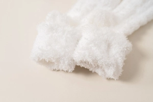 Close-up of soft white coral fleece socks showing thick plush texture and warm material