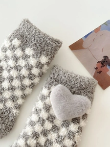 Detail of coral fleece thick socks featuring grey checkerboard pattern and plush heart
