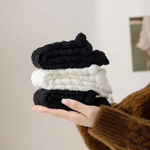 Detailed view of thick white and black coral fleece socks in a soft plush texture