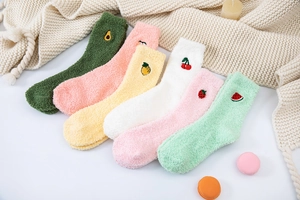 Detailed view of plush coral fleece socks with colorful cute fruit embroidery and warm texture