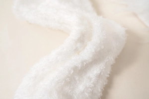 Close-up of white coral fleece fabric showing soft texture for winter socks and blankets