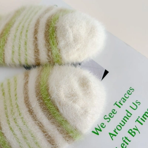 Macro shot of fluffy striped mink velvet socks showing soft texture and green color