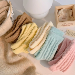Detail of five assorted thick knit socks in warm autumn tones with cable-knit texture