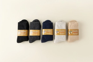 Detailed knit texture of five pairs of thick wool socks in grey and beige colors