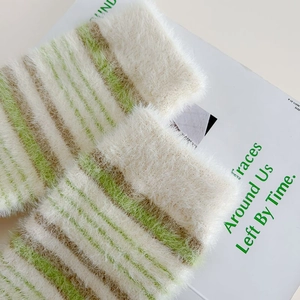 Macro detail of plush striped mink cashmere socks in green, white and khaki colors