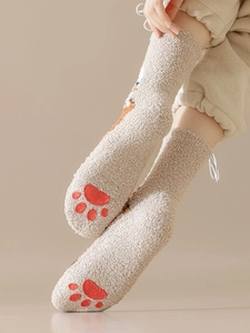 Close-up of warm beige coral fleece socks featuring cute cat paw prints and embroidery