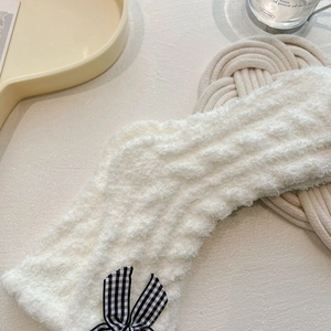 Close-up of fluffy white coral fleece headband with black and white checkered bow detail